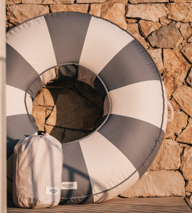 Round gray and white checkered cushion on a stone wall background